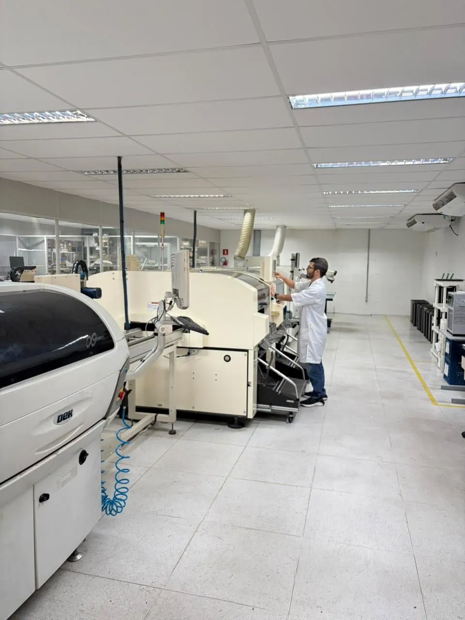 Área de montagem SMT da Valexcell, com impressora de pasta de solda e técnico operando a linha