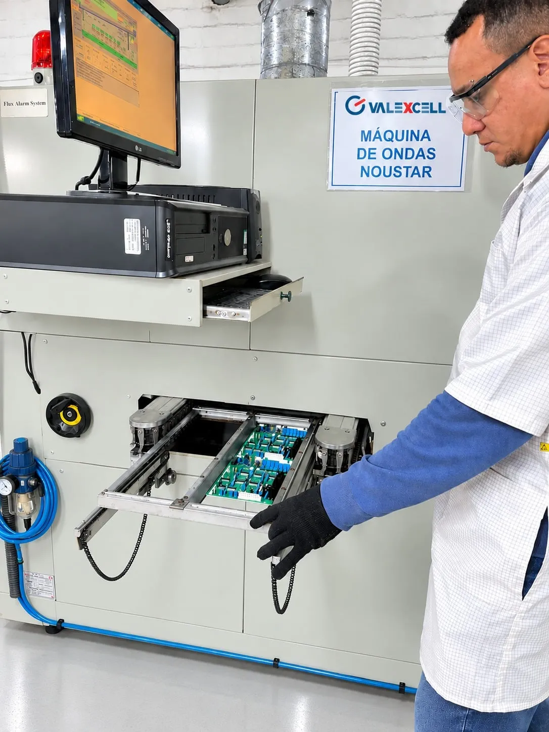 Técnico retirando placa eletrônica da máquina de solda por onda